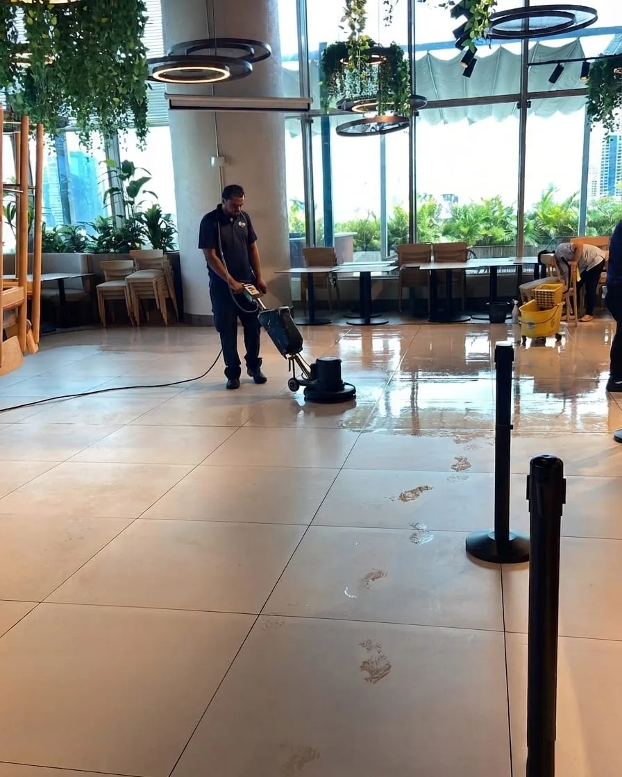 Personal de Go Services puliendo el piso de un lobby corporativo